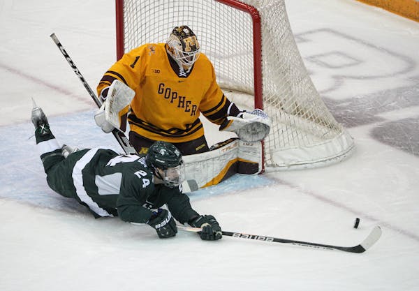 Michigan State outshot the Gophers in the first period. Here, Gophers goalie Justen Close stopped a shot by Michigan State's Erik Middendorf.