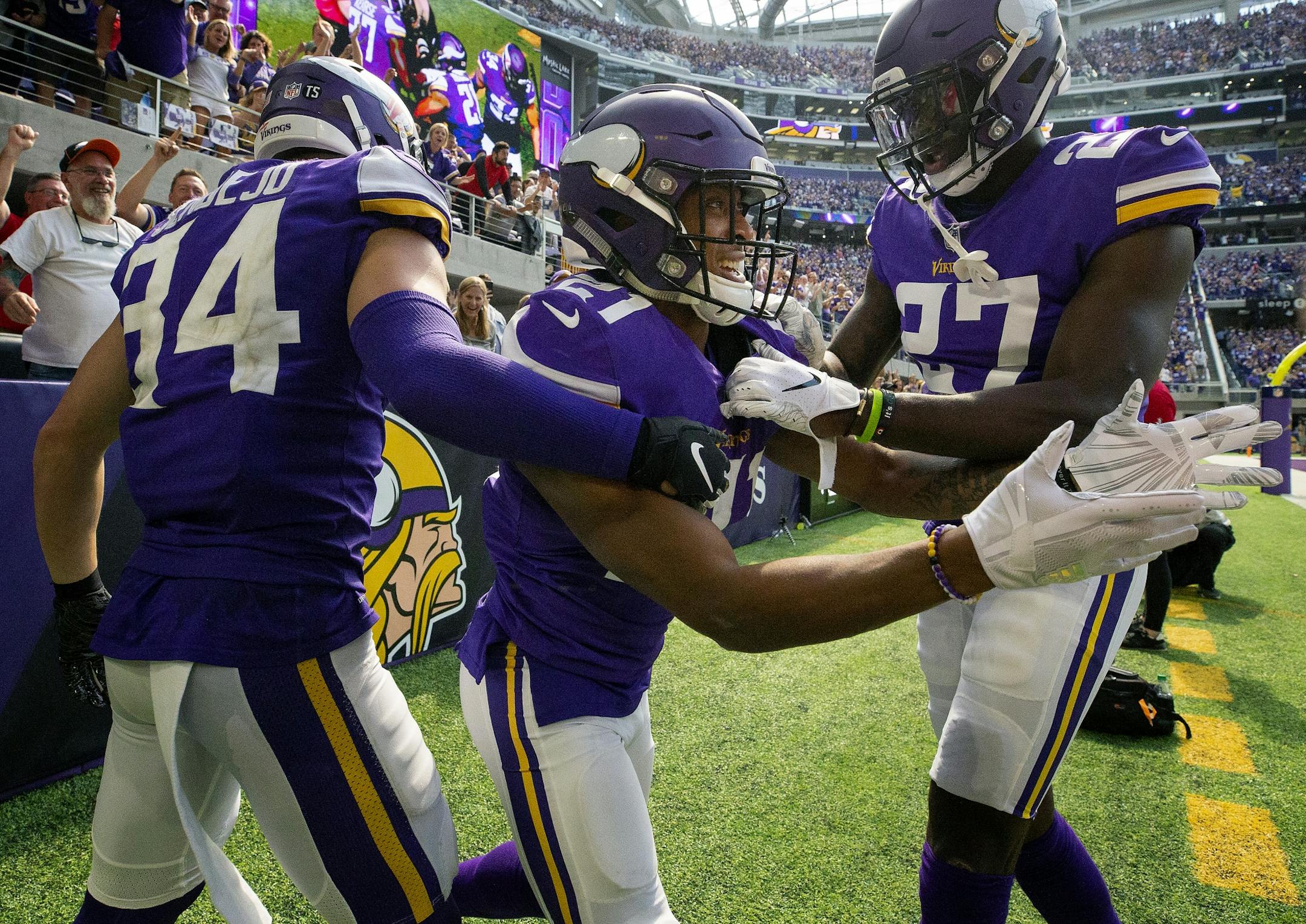 Mike Hughes (21) celebrated with teammates Andrew Sendejo and Jevon Kearse after returning an interception 28-yards for a touchdown in the third quarter.