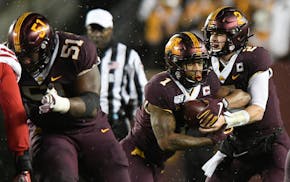 Right guard Curtis Dunlap Jr. (51) cleared a path for Gophers running back Rodney Smith, taking a handoff from quarterback Tanner Morgan against Nebra