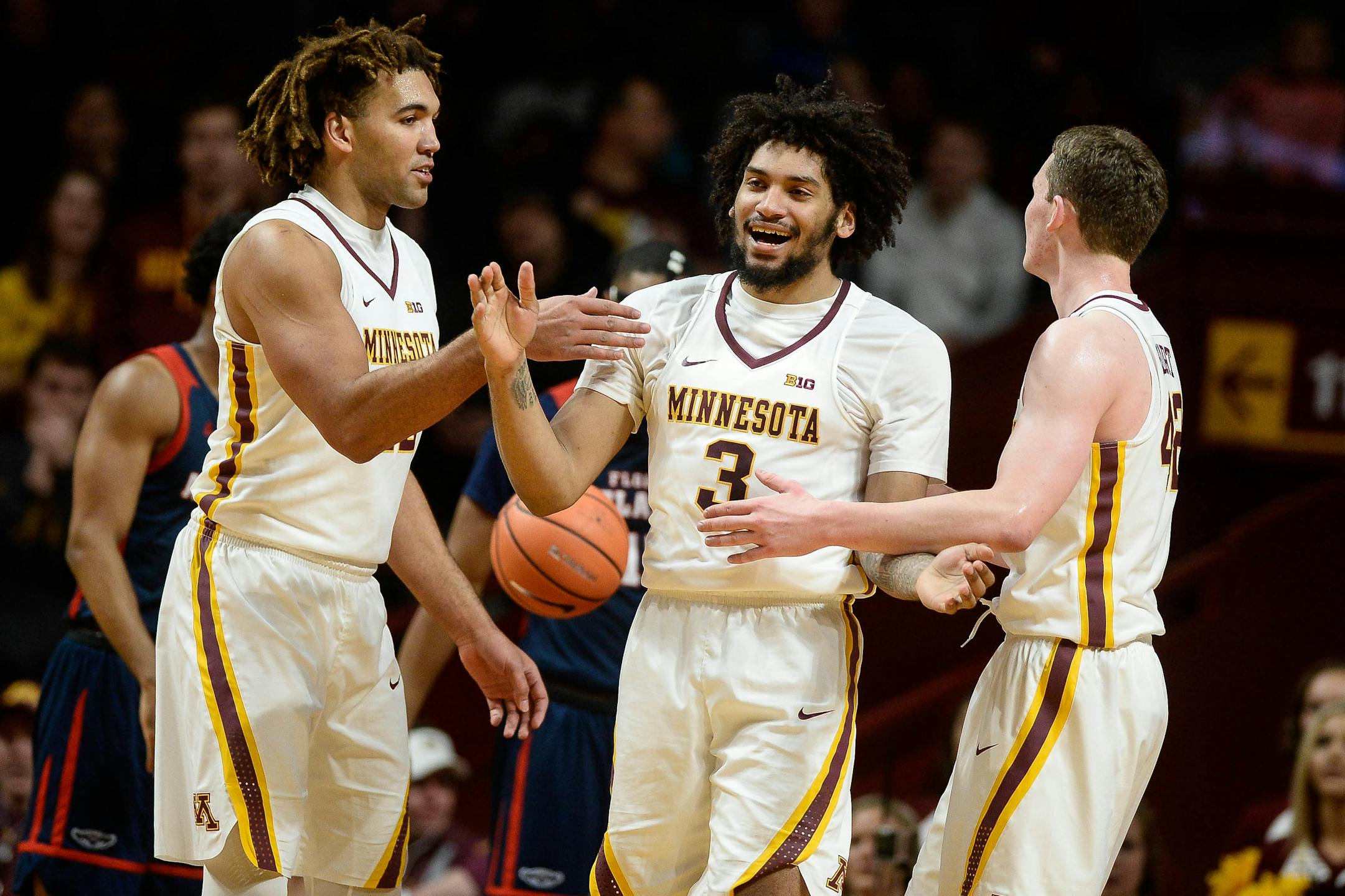 Minnesota Golden Gophers center Reggie Lynch (22) and forward Michael Hurt (42) high-fived forward Jordan Murphy (3) after Murphy was fouled on his way to the basket in the first half against Florida Atlantic earlier this season.