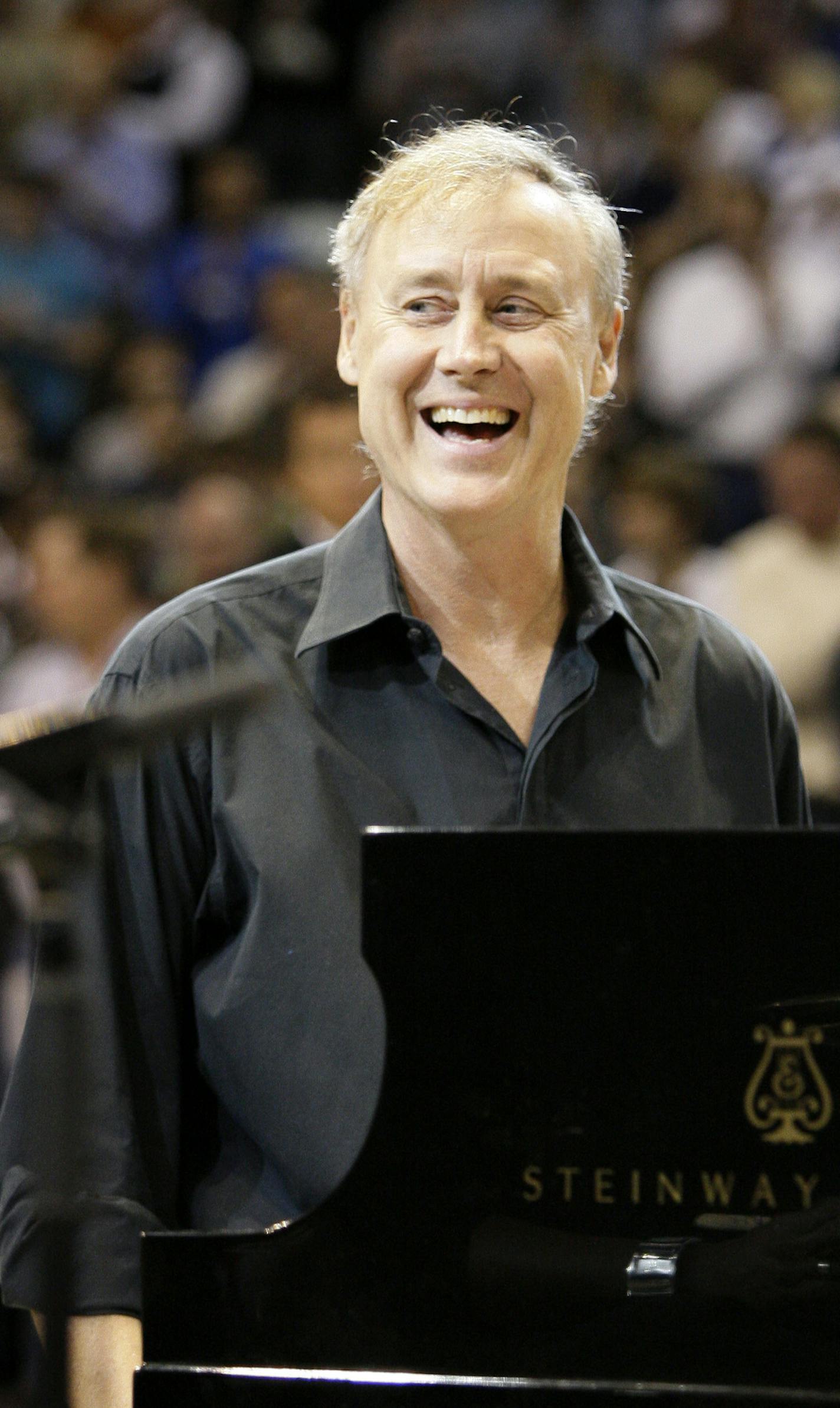 Singer songwriter Bruce Hornsby smiles as he acknowledges cheers from fans after playing the national anthem before the start of the NBA basketball game between the Dallas Mavericks and Washington Wizards, Tuesday, Oct. 27, 2009, in Dallas. (AP Photo/Tony Gutierrez) ORG XMIT: DNA101