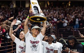 South Carolina coach Dawn Staley carries the NCAA women's college basketball title trophy around Colonial Life Arena during a team celebration April 8