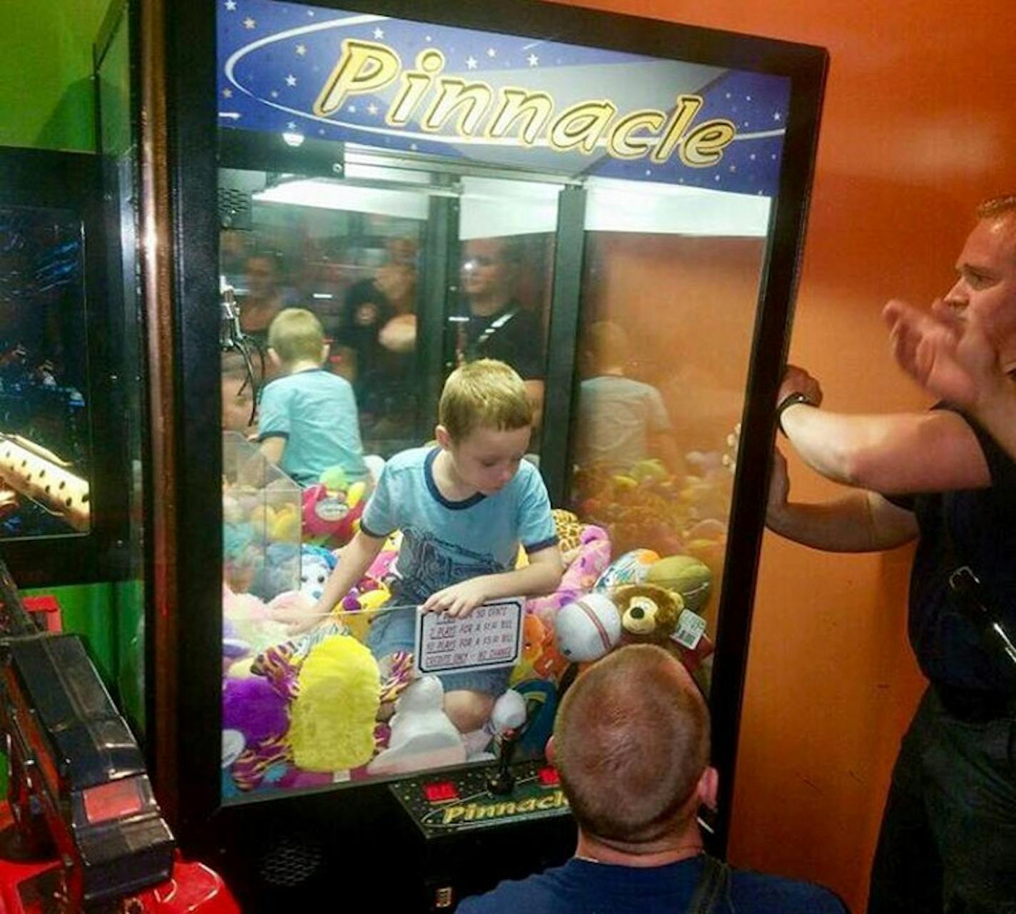 Fire fighters work to free a boy who crawled inside a claw-style vending machine in Titusville, Fla.