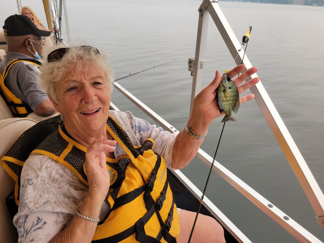 Donna Andrews of Eden Prairie held up a bluegill. She grew up in Wisconsin learning the joys of fishing from her father.