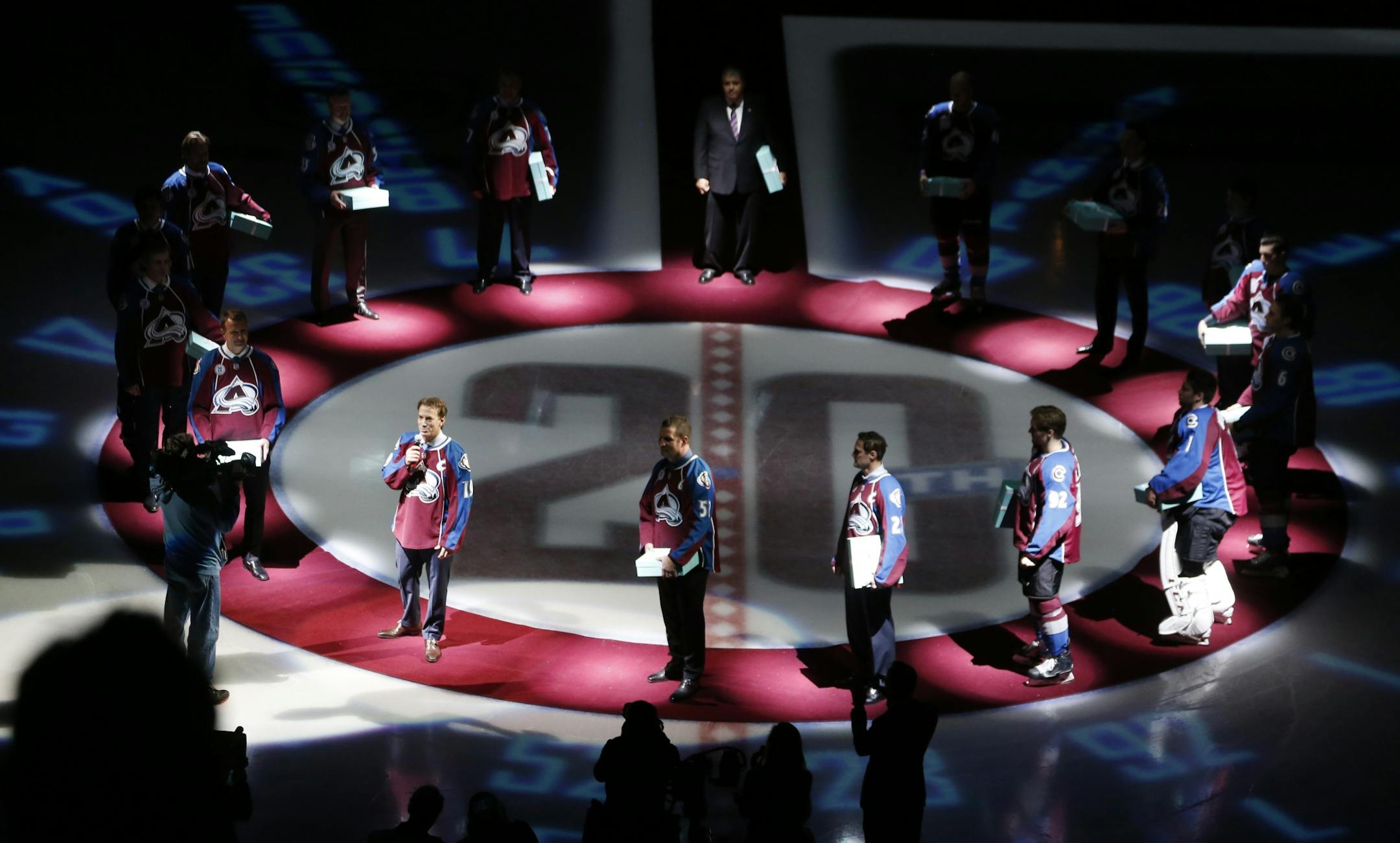 Members of the 20th anniversary team selected by fans of the Colorado Avalanche gather at center ice for ceremony before the Avalanche host the Minnesota Wild in the first period of an NHL hockey game Monday, Dec. 7, 2015, in Denver.