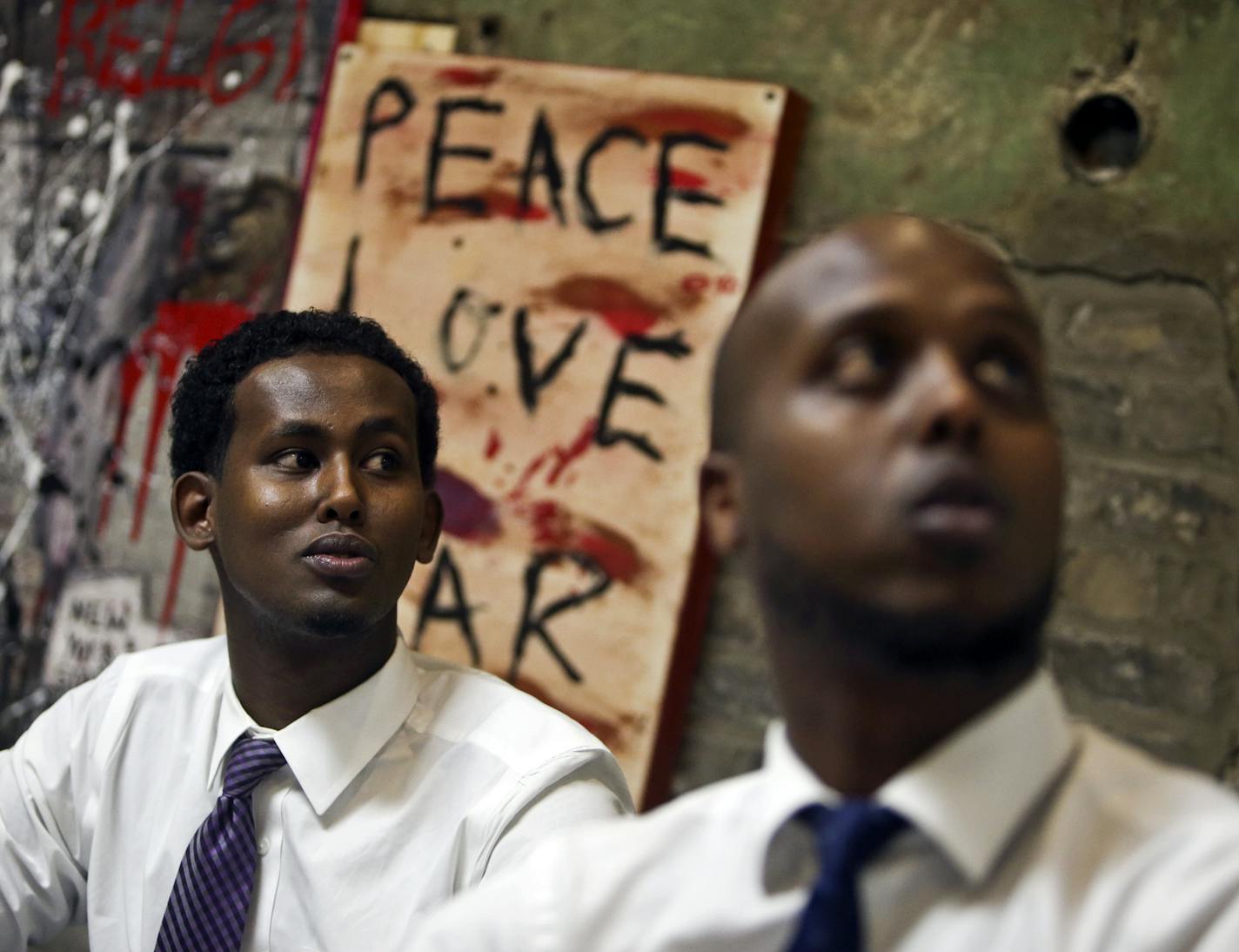 Abdifatah Farah, right, Ka Joog articistic director, and Daud Mohamed, Ka Joog vice president and special projects manager, look at at a hanging banner at the Ka Joog office, that says "no tribalism" Thursday, Sept. 26, 2013,in Minneapolis, MN. Ka Joog means "to stop" or "stay away" and according to members means away from terrorism, gangs, tribalism and other ills that have struck some of the Somali American youth. "Right now everyone's on the same page," Farah said, in recognizing that Al-Shab