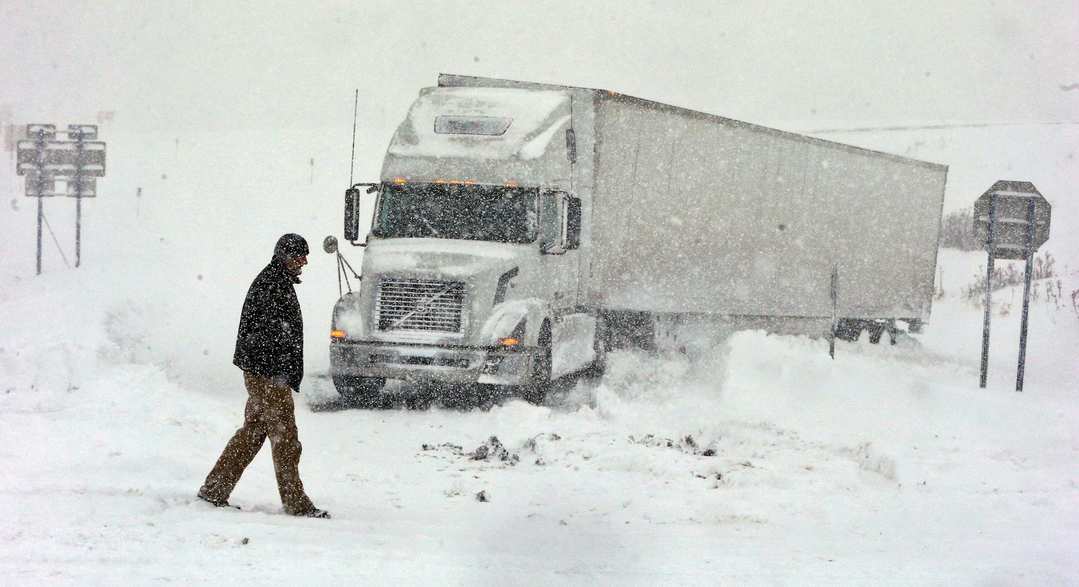 Omer Odovsc walks in front of his tractor trailer that got stuck on the 219 off ramp leading to Rt. 391 in Boston, N.Y., Tuesday, Nov. 18, 2014. Parts of New York measured the season's first big snowfall in feet, rather than inches, on Tuesday as 3 feet of lake-effect snow blanketed the Buffalo area and forced the closure of a 132-mile stretch of the state Thruway. (AP Photo/The Buffalo News, Harry Scull Jr.) TV OUT; MAGS OUT; MANDATORY CREDIT; BATAVIA DAILY NEWS OUT; DUNKIRK OBSERVER OUT; JAMES