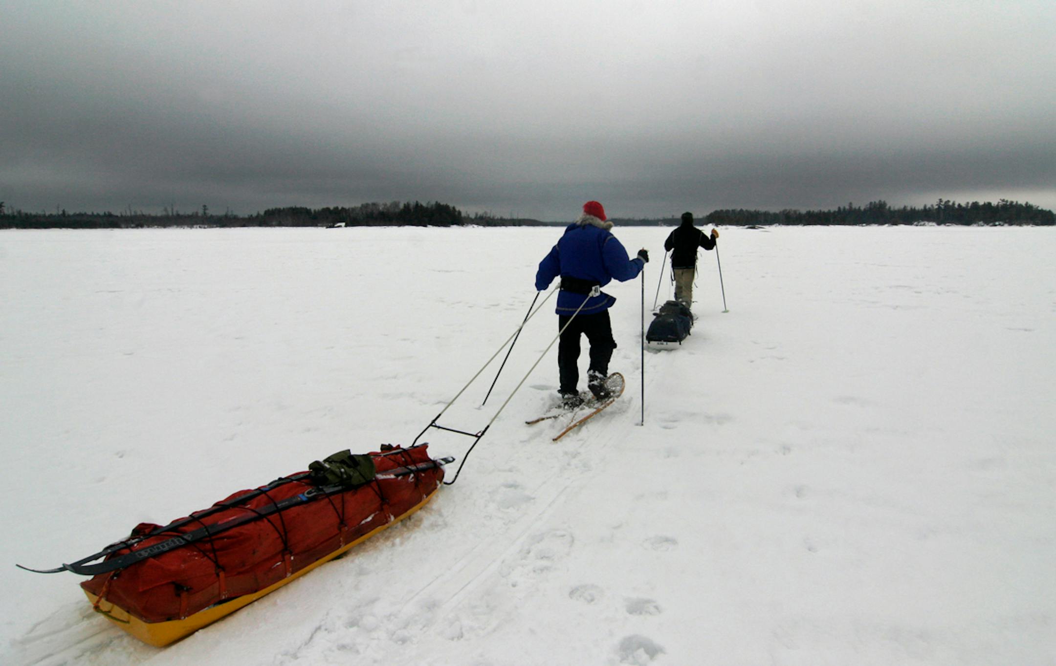 Sam Cook of Duluth and Steve Piragis of Ely head across a BWCA lake looking for a campsite under an ominous sky. Doug Smith/Star Tribune.