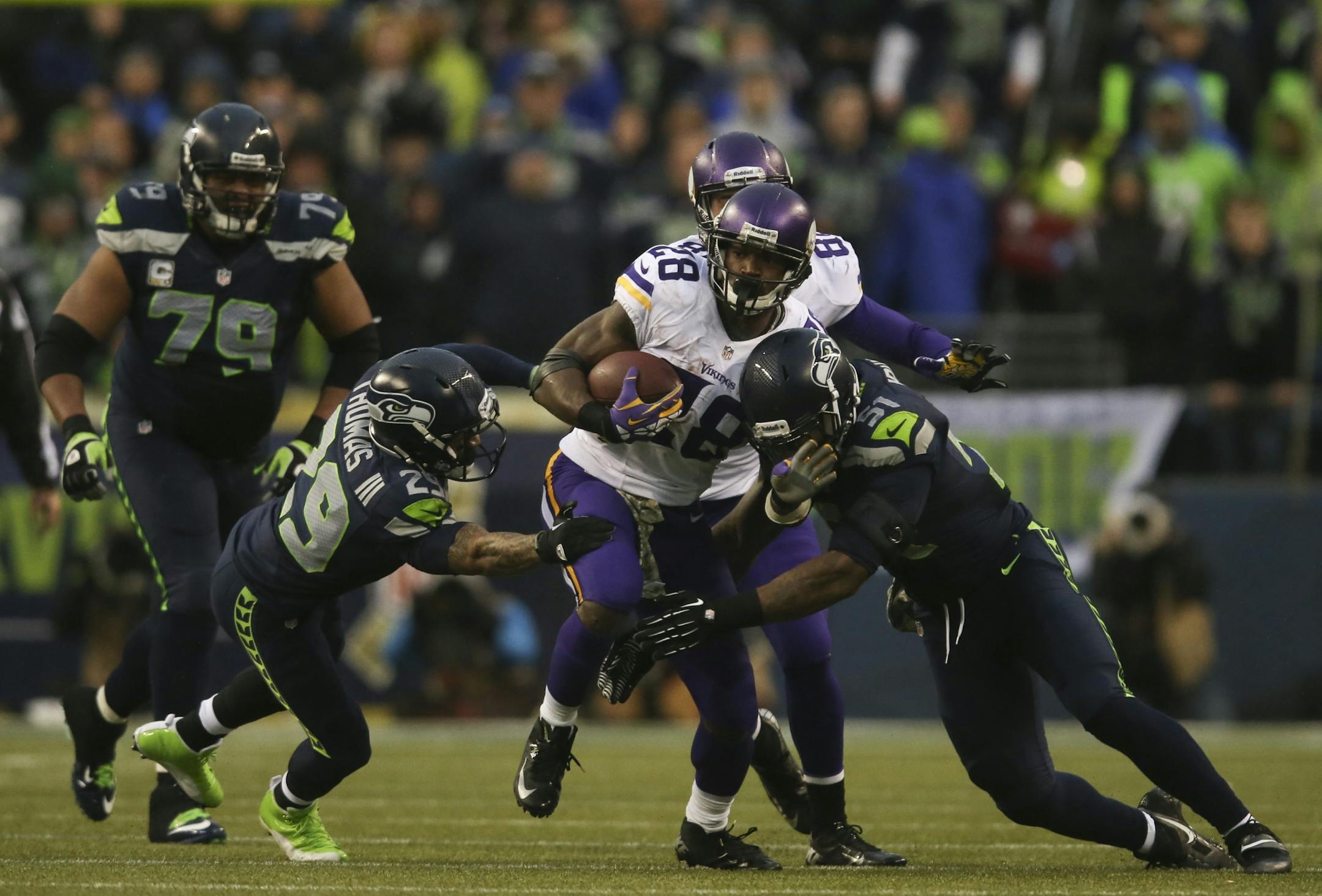 The Minnesota Vikings lost 41-20 to the Seattle Seahawks in an NFL game Sunday afternoon, November 17, 2013 at CenturyLink Field in Seattle. Minnesota Vikings running back Adrian Peterson (28) tried to slip between Seattle Seahawks free safety Earl Thomas (29) and Seattle Seahawks outside linebacker Bruce Irvin (51) on a 13 yard gain in the third quarter.