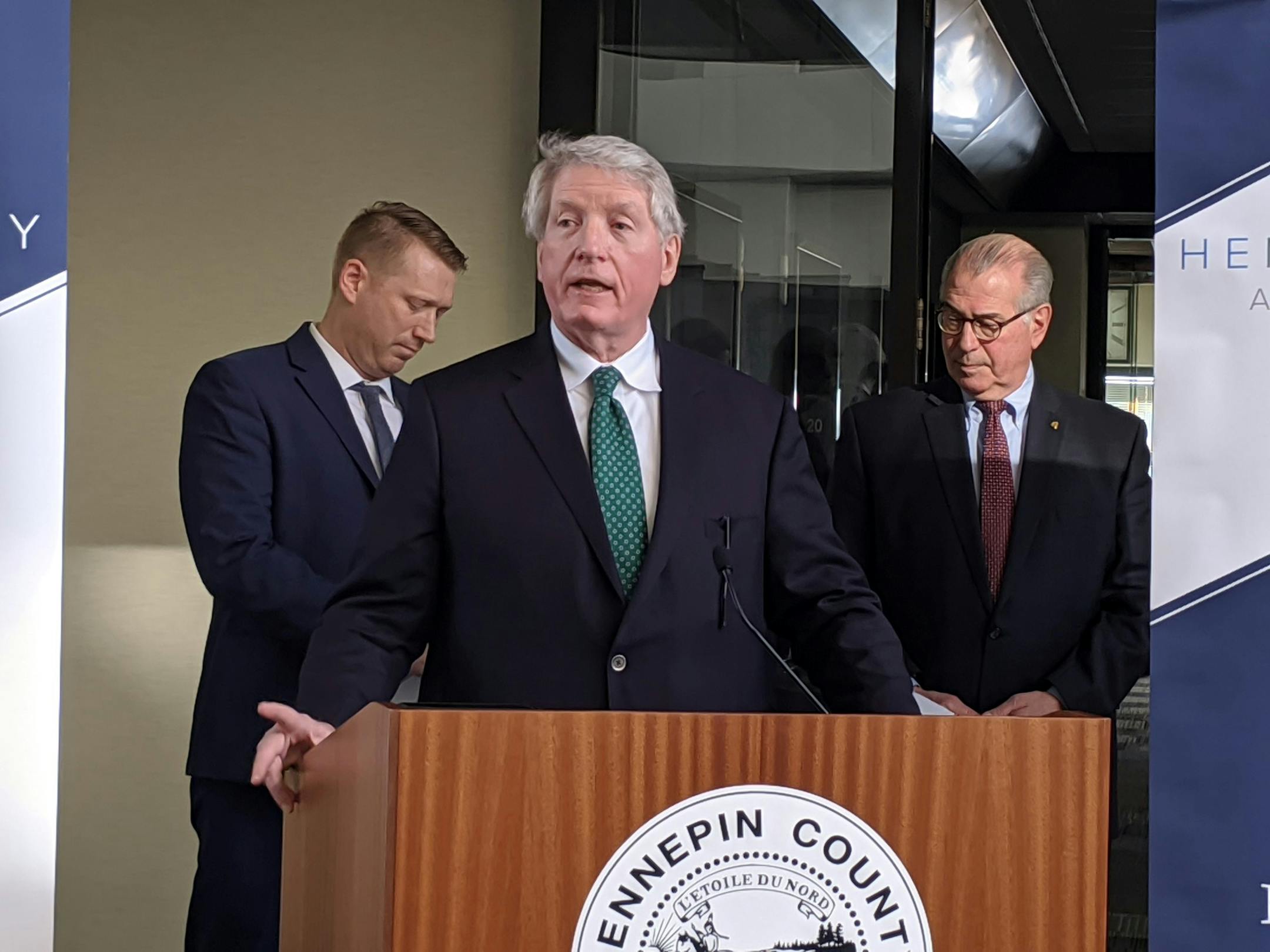 Minnesota Department of Commerce Commisioner Steve Kelley speaks at a morning news conference about felony charges against Leroy and Joyce Merit, who are accused of lying about the employees' status to save money on workers' compensation insurance.Burt Johnson (left), an attorney for the North Central States Regional Council of Carpenters union, and Hennepin County Attorney Mike Freeman (right), flank Kelley.