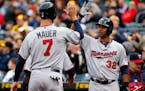 Minnesota Twins' Joe Mauer (7) is greeted by Aaron Hicks (32) after scoring on a three-run double by Torii Hunter off Pittsburgh Pirates starting pitc