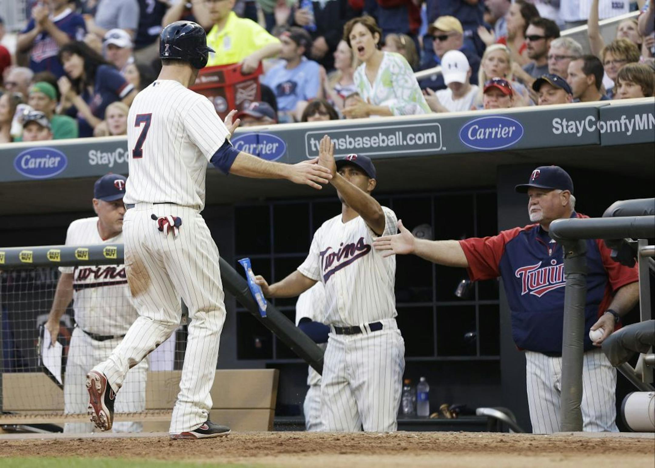 Minnesota Twins' Joe Mauer, left, is congratulated by manager Ron Gardenhire, right, after Mauer scored on a single by Justin Morneau in the fourth inning of a baseball game against the Boston Red Sox, Saturday, May 18, 2013, in Minneapolis.