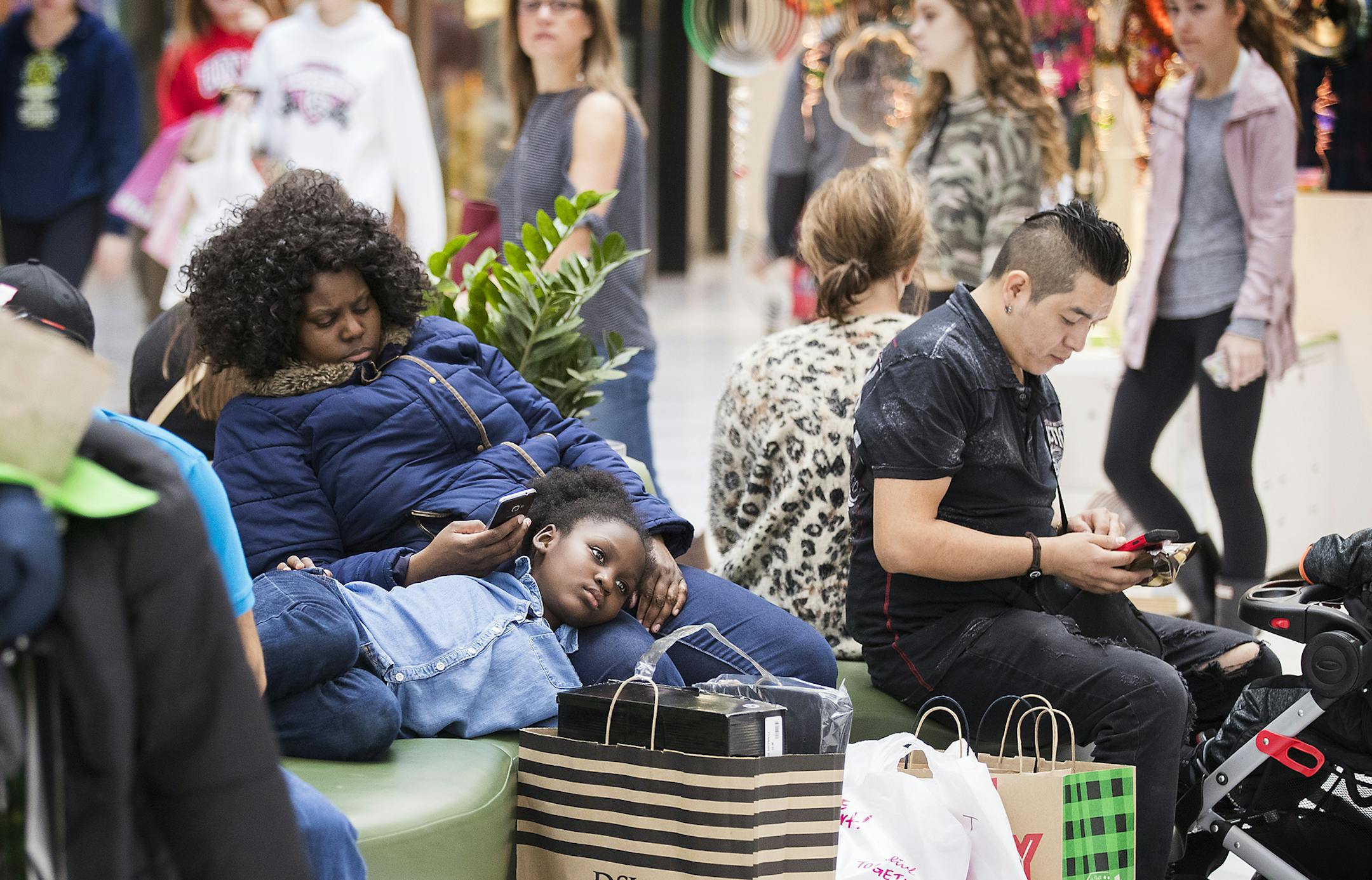 Irene Slaughter-Janneh of Minneapolis rests with her daughter Serreh Janneh, 8, at Mall of America on Black Friday. ] LEILA NAVIDI ï leila.navidi@startribune.com BACKGROUND INFORMATION: Black Friday at Mall of America in Bloomington on Friday, November 24, 2017.