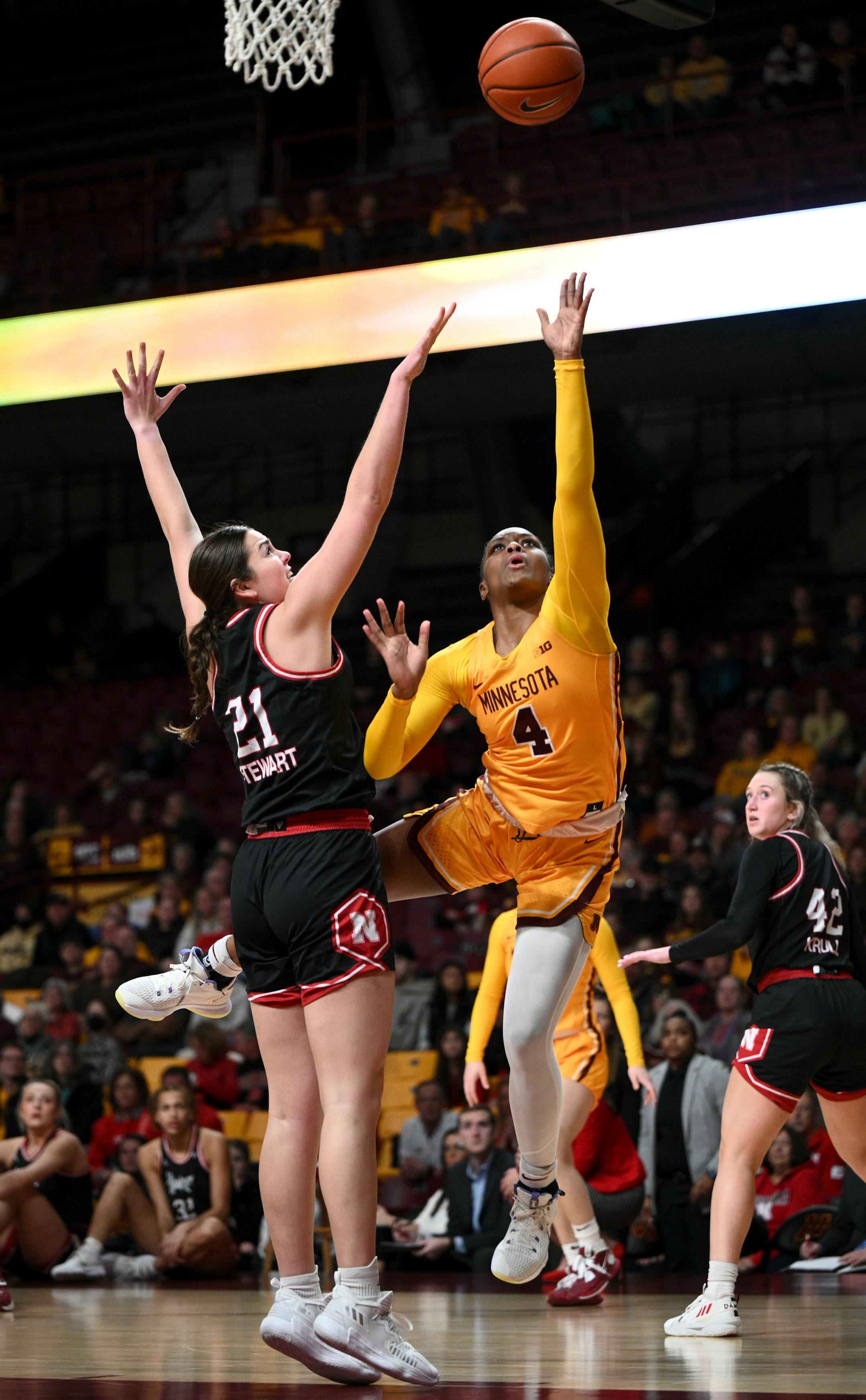 Minnesota forward Alanna Micheaux (4) is fouled by Nebraska forward Annika Stewart (21) as she scores a layup during the first half.