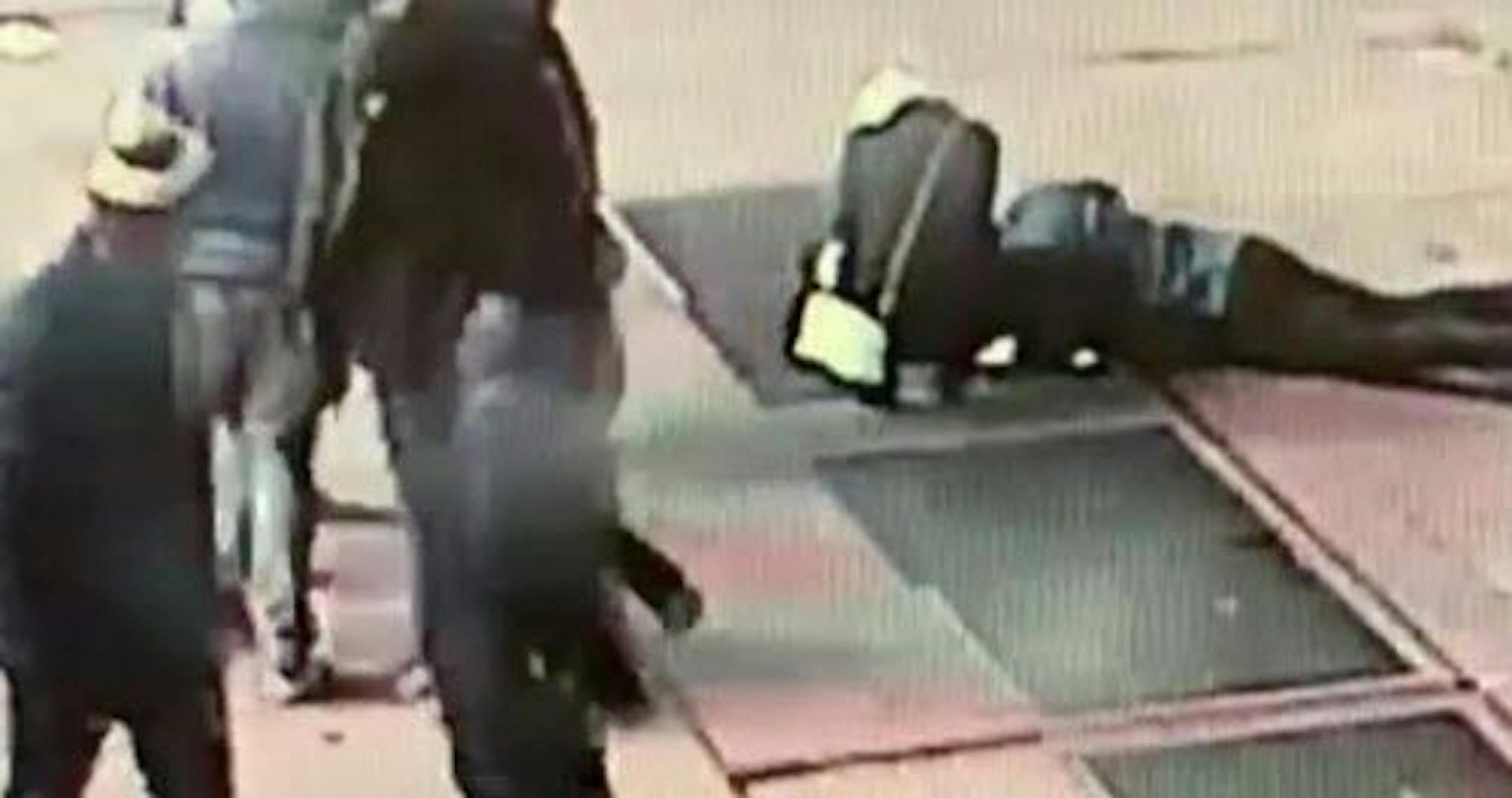 In this Nov. 30, 2018 image taken from surveillance video provided by the New York City Police Department, a man tries to see the engagement ring that he dropped down a utility grate on New York's Times Square. The New York City Police Department says the man was proposing to his girlfriend just before midnight Friday when he dropped the ring and it fell about eight feet down the utility grate.