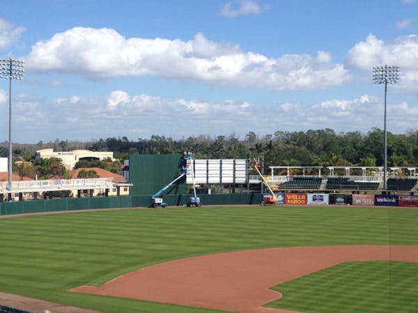 Workers install the batter's eye at the Twins' home field for spring training on Saturday.