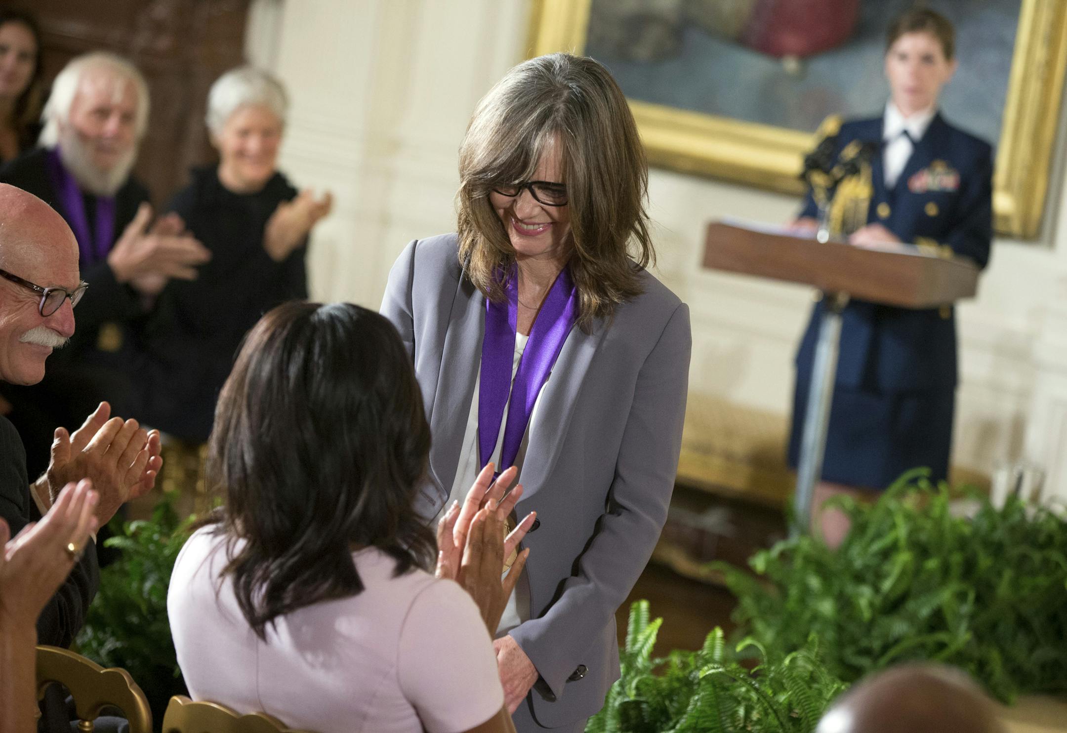 Acress and filmmaker Sally Field of Los Angles, center, smiles at first lady Michelle Obama, bottom left, after President Barack Obama awarded her the 2014 National Medal of Arts during a ceremony in the East Room at the White House in Washington, Thursday, Sept. 10, 2015. (AP Photo/Andrew Harnik)