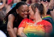 Spouses Catima Wilson, 41, left, and Stephanie Wilson, 41, of Eagan, Minn. share a moment together during the Twin Cities Pride Festival at Loring Par