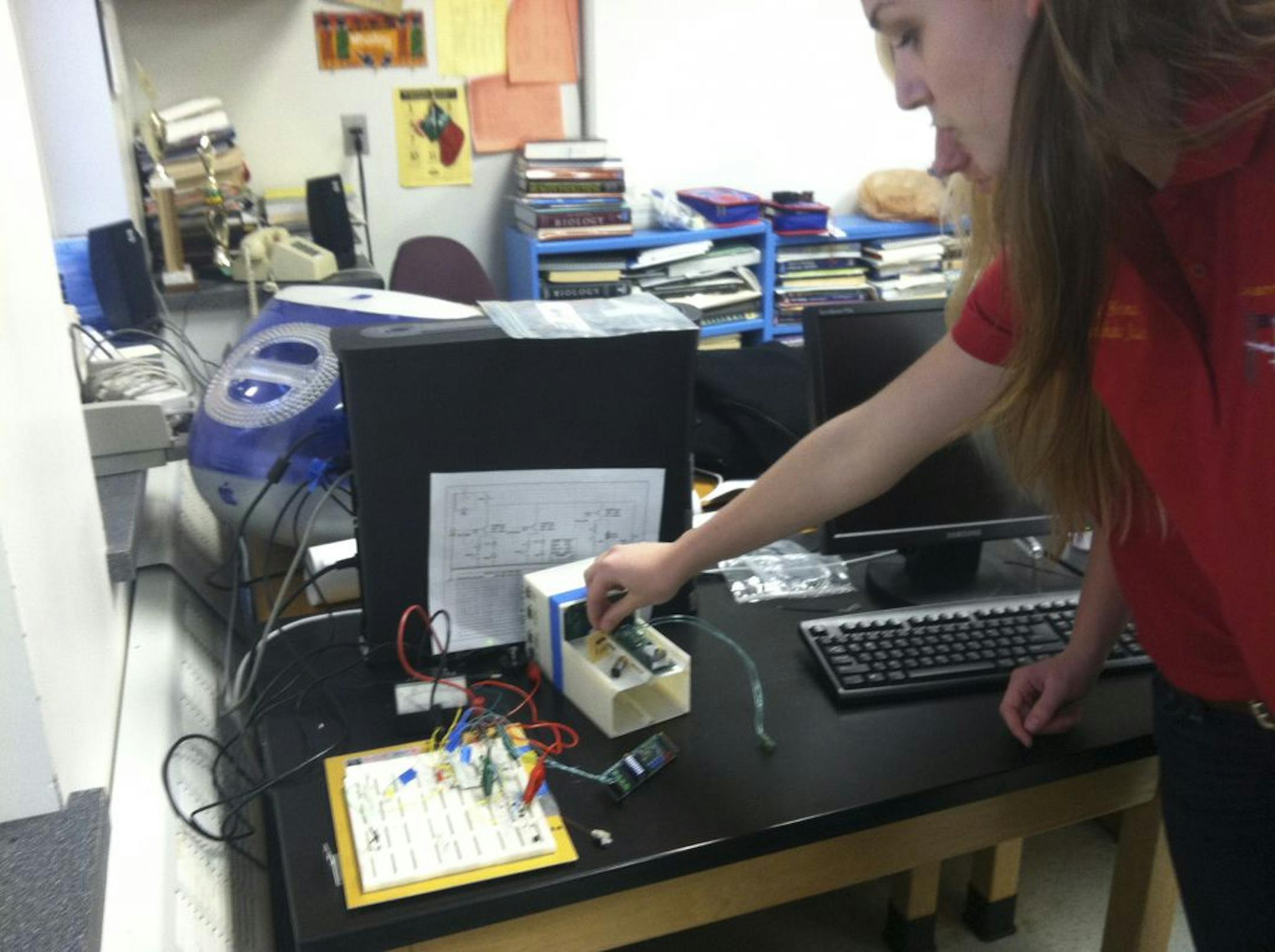 Minnehaha Academy junior Viola Holman shows the circuit board and pieces of equipment to be sent into that will have to fit into a small box that's 2 inches wide by 4 inches long.