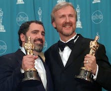FILE - James Cameron, right, and Jon Landau hold the Oscars for Best Picture for the film "Titanic" at the 70th annual Academy Awards at the Shrine Au