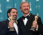 Producer Jon Landau, left, and director James Cameron hold the Oscars for Best Picture for the film "Titanic" at the 70th annual Academy Awards at the