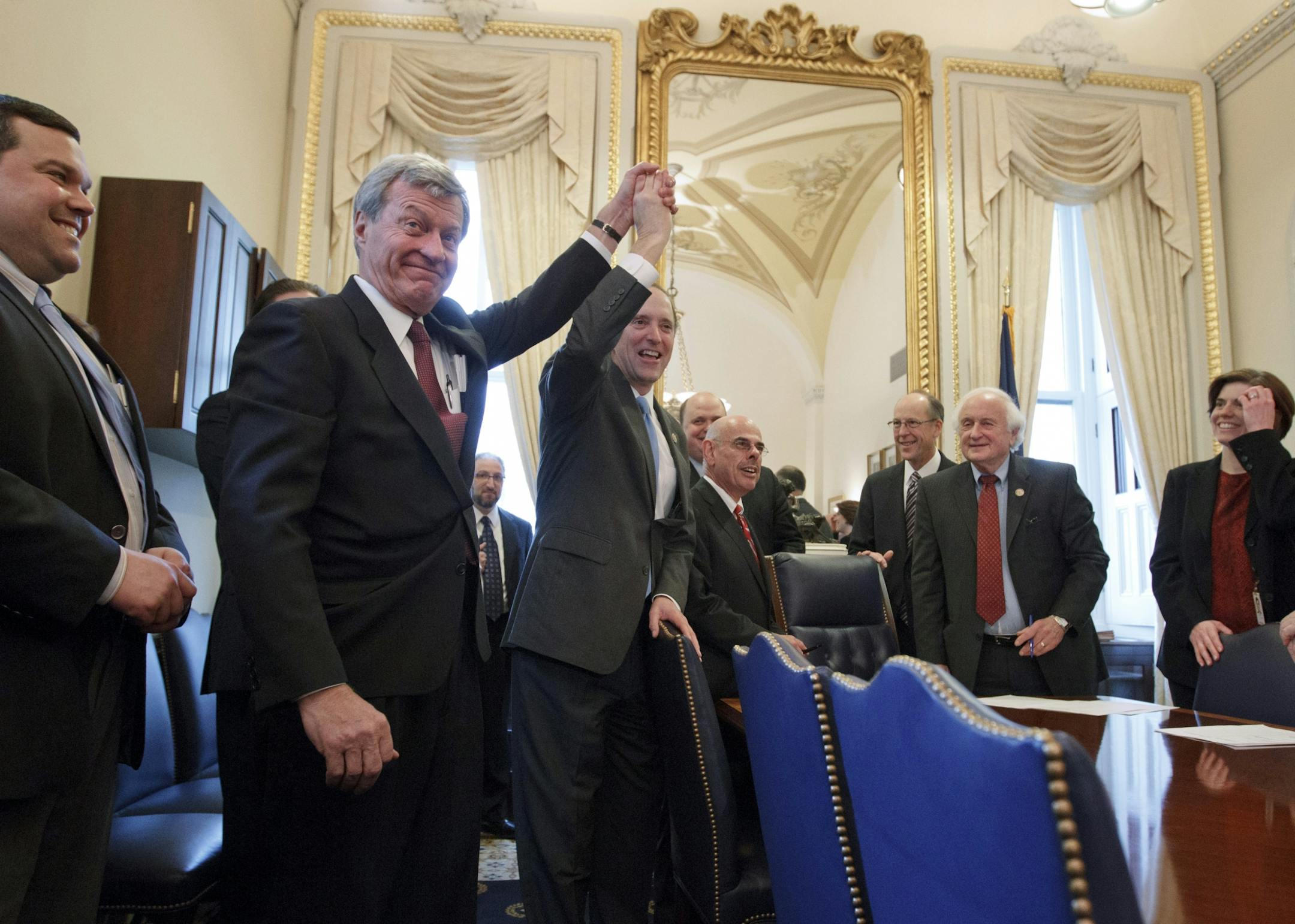 Senate Finance Committee Chairman Sen. Max Baucus, D-Mont., left, joins hands in celebration with House Ways and Means Committee Chairman Rep. David Camp, R-Mich., as the bi-partisan House and Senate conferees gather to sign the compromise agreement on Capitol Hill in Washington, Thursday, Feb. 16, 2012. From left are, Baucus, Camp, R-Mich., Rep. Tom Reed, R-NY, Rep. Henry Waxman, D-Calif., Rep. Greg Walden, R-Ore., and Rep. Sander Levin, D-Mich.