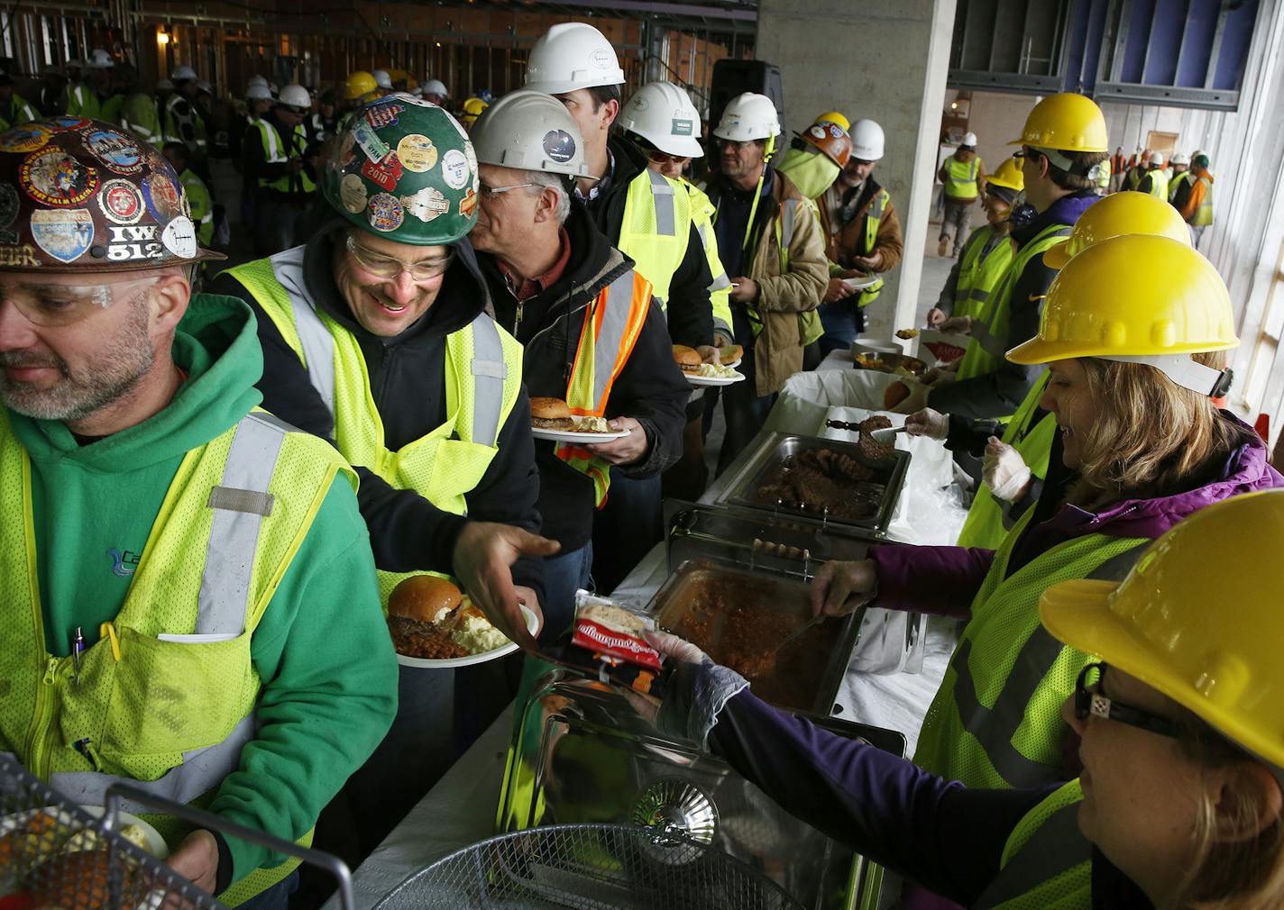 Iron workers line up with other Vikings stadium construction workers for a free lunch provided by the Vikings organization on Friday, December 12, 2014. ] LEILA NAVIDI leila.navidi@startribune.com /