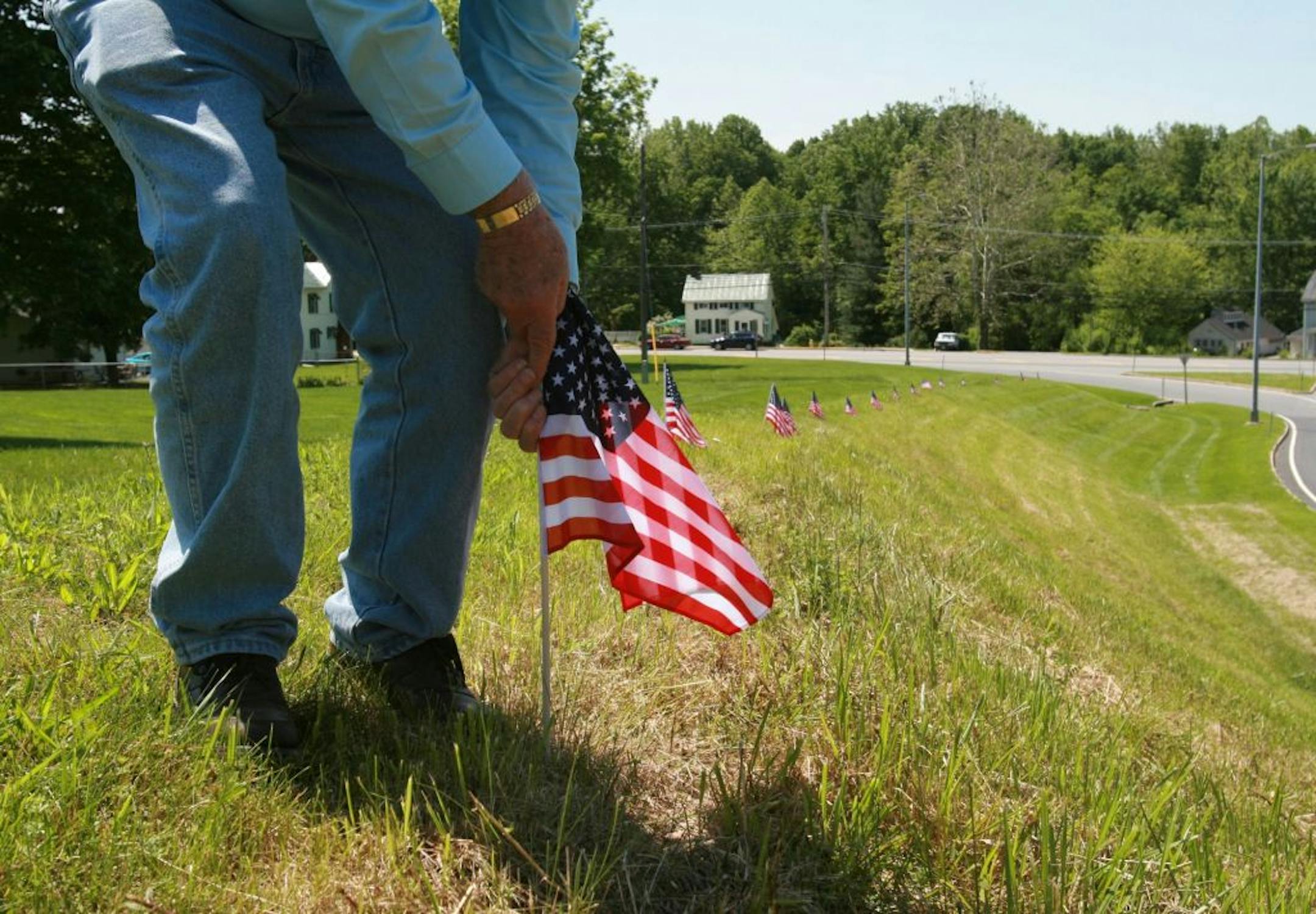 Jim Stull, 78, a life long resident of Thurmont, Md, places American flags along the exit ramp from Route 15 to Route 77 on Thursday, May 17, 2012 in Thurmont, Md. The ramp will be the main travelway for dignitaries motorcading to Camp David for the G8 Summitt. Thurmont, a small mountain town near Camp David, is bracing for the expected arrival of demonstrators bent on disrupting a weekend meeting at the presidential retreat of leaders of the Group of Eight leading industrialized nation.