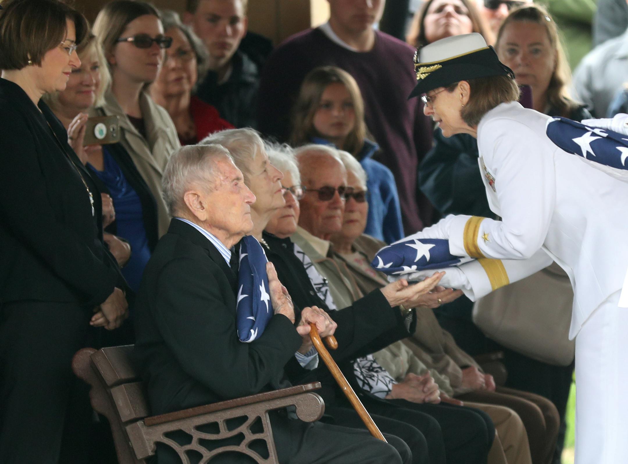 Near the conclusion of the internment for Quentin Gifford his brother Harold Gifford of Woodbury, holds the flag that draped his brother's casket as Rear Adm. Linnea J. Sommer-Weddington presents a flag to Quentin's sister June Shoen of Warroad at Fort Snelling National Cemetery Saturday, May 12, 2018, in Minneapolis, MN.] DAVID JOLES ï david.joles@startribune.com Quentin Gifford, who as a young sailor on the USS Oklahoma was killed at Pearl Harbor, will be buried with aNavy Honors Saturday