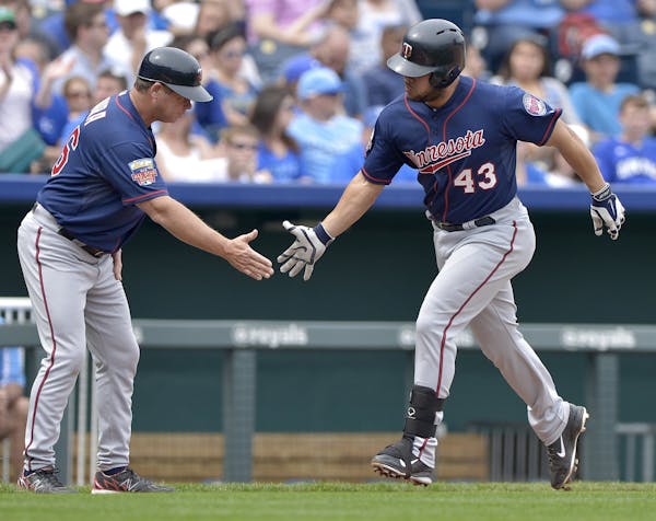The Minnesota Twins' Josmil Pinto (43) is congratulated by third base coach Joe Vavra after hitting a home run in the fifth inning against the Kansas 