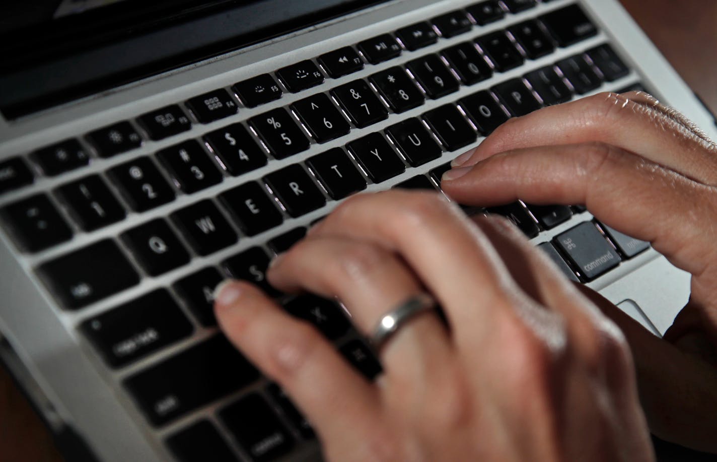 FILE- In this June 19, 2017, file photo, a person types on a laptop keyboard in North Andover, Mass. The availability of remote work has increased significantly in recent years, giving rise to the ability for telecommuters to buck travel norms. Remote work has blurred the line between business and personal travel, affording workers the flexibility to extend trips to fly on cheaper days. (AP Photo/Elise Amendola, File) ORG XMIT: NYBZ206