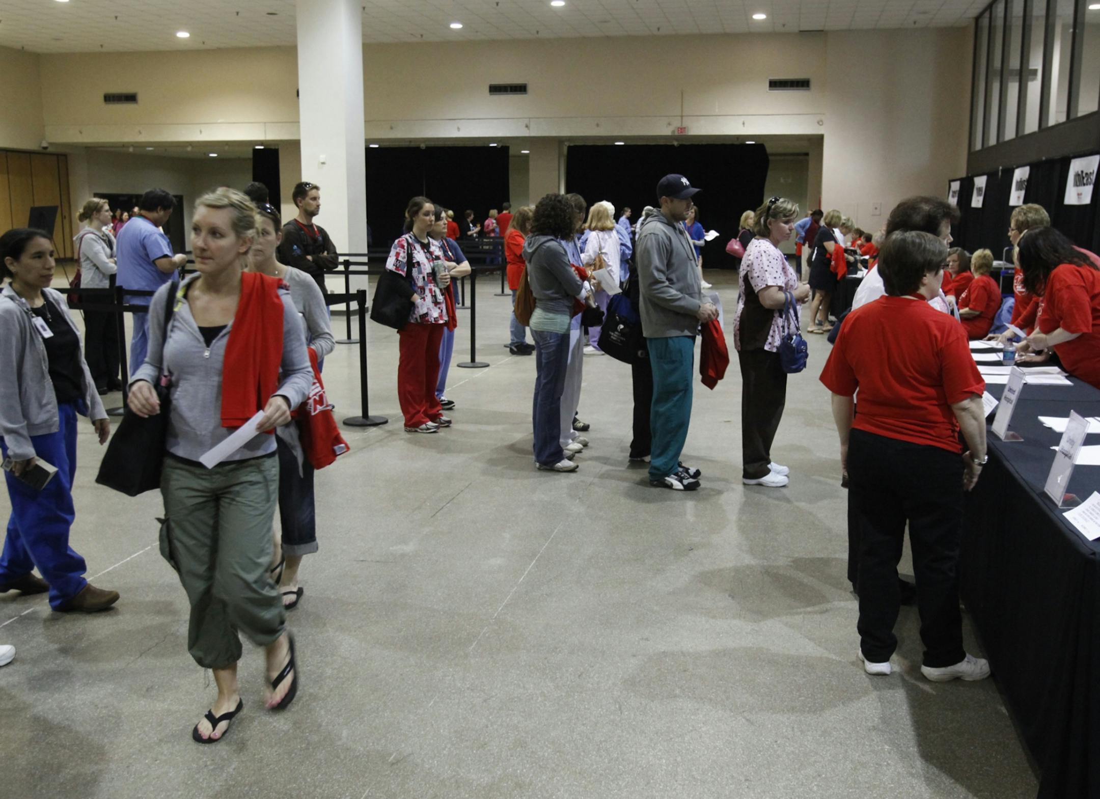 Nurses register to vote while others hold their ballots on the way to cast them.