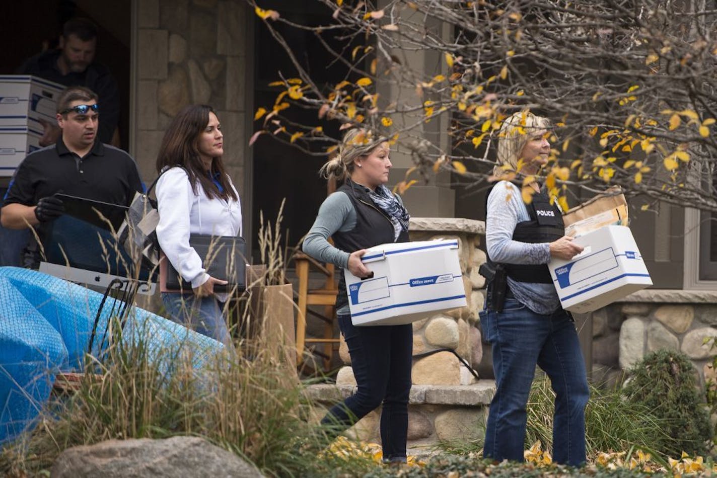 Law enforcement left the home of former Starkey Hearing Technologies President Jerry Ruzicka carrying evidence including a computer and boxes of documents Wednesday afternoon, Nov. 4, 2015, in Plymouth, Minn.