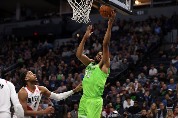 Timberwolves center Karl-Anthony Towns shoots next to Trail Blazers forward Trendon Watford during the first half Saturday.