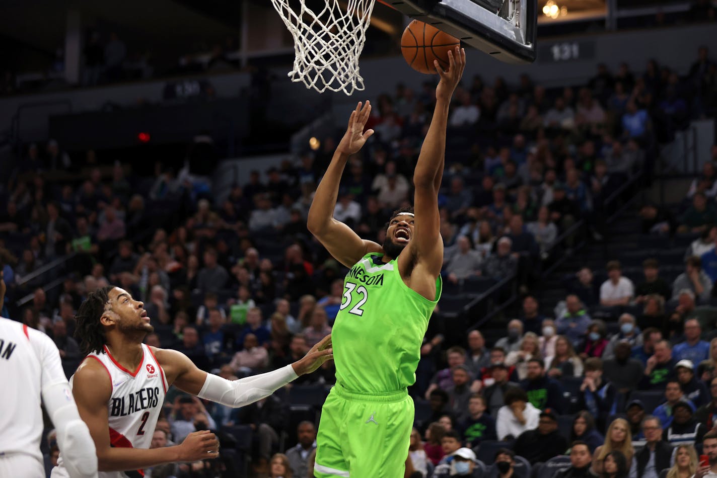 Timberwolves center Karl-Anthony Towns shoots next to Trail Blazers forward Trendon Watford during the first half Saturday.