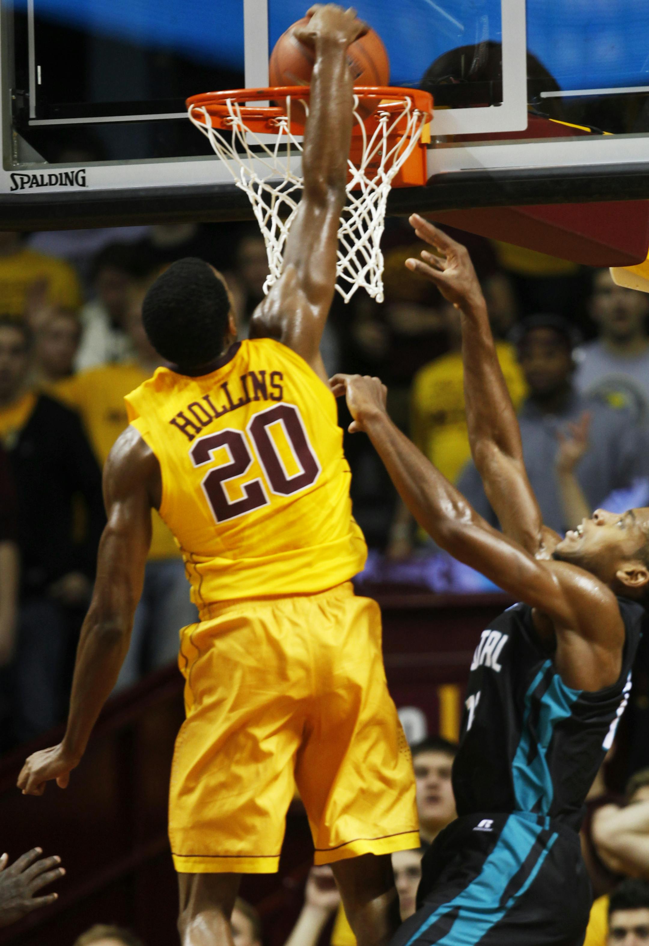 At Williams Arena in a game between the Gophers mens basketball team and Coastal Carolina, Austin Hollins(20) dunks one as Michel Enanga(12) defends.]richard tsong-taatarii/rtsong-taataarii@startribune.com