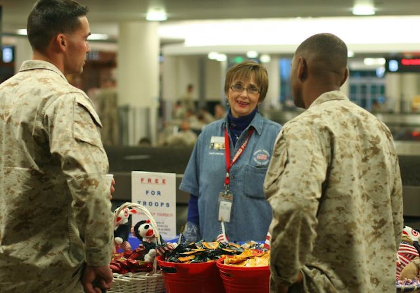 Volunteer Annie Olson (center) chats with several Marines has their unit passes through the Minneapolis-St. Paul Airport recently.