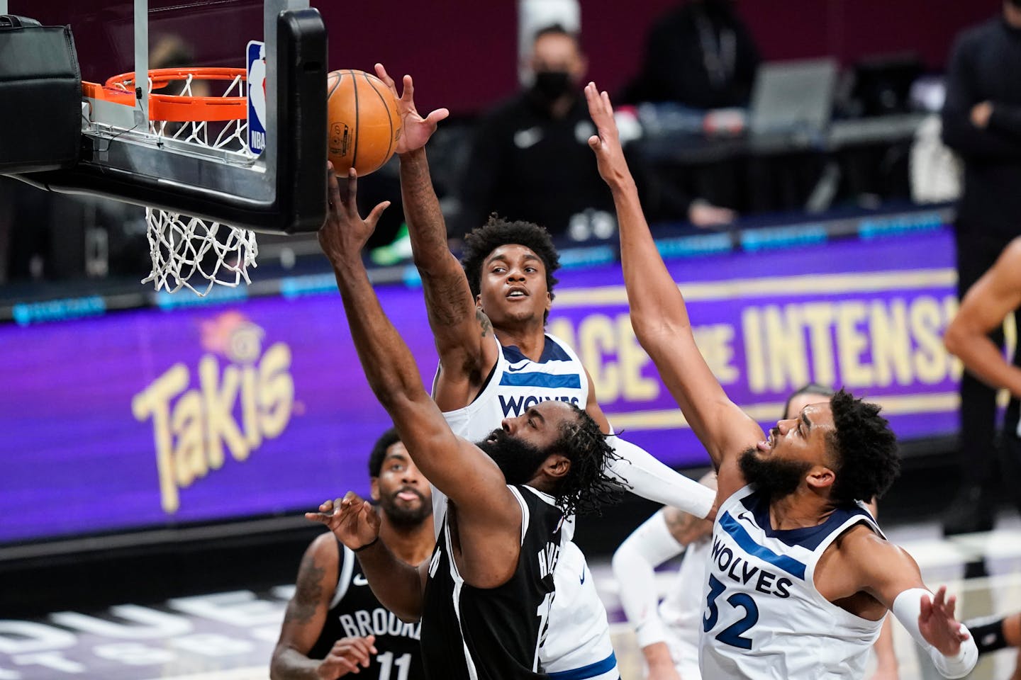 Brooklyn Nets' James Harden, center, drives past Minnesota Timberwolves' Karl-Anthony Towns (32) and Jaden McDaniels during the first half of an NBA basketball game Monday, March 29, 2021, in New York. (AP Photo/Frank Franklin II)