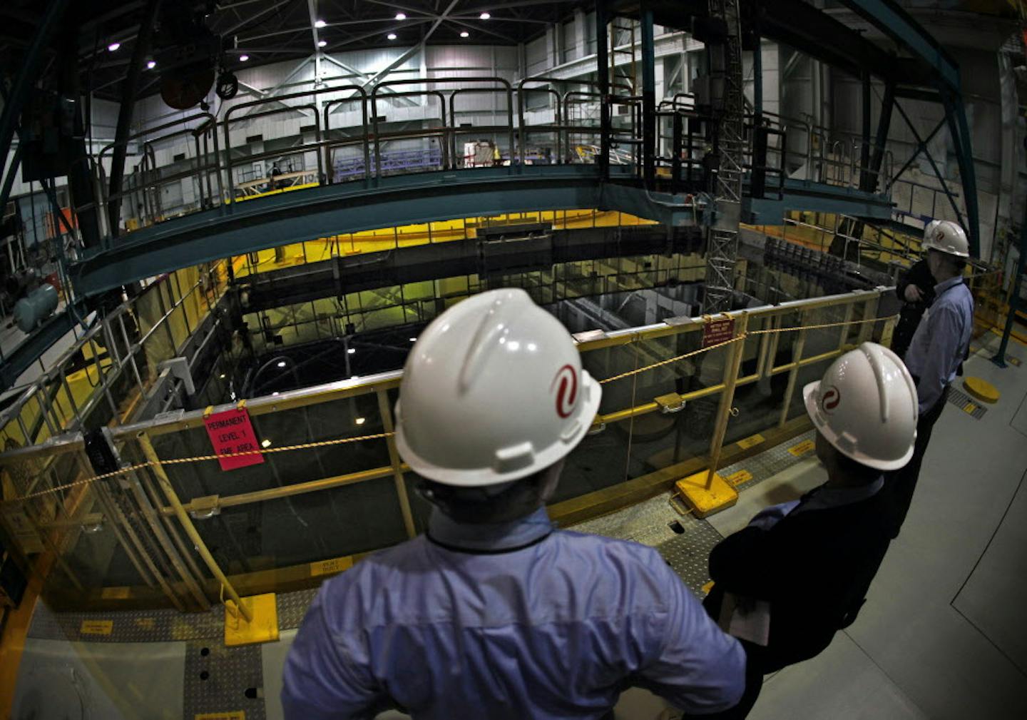 Xcel Energy officials and others examine the 38-foot-deep pool which holds spent fuel rods taken out of the reactor. The rods, covered by 24 feet of water, simmer for about a decade before they are moved to casks that are stored outdoors. Cranes above the pool help move the assemblies of fuel rods. ] JIM GEHRZ&#x201a;&#xc4;&#xa2;jgehrz@startribune.com (JIM GEHRZ/STAR TRIBUNE) / February 28, 2012 / 9:00 AM , Monticello, MN** BACKGROUND INFORMATION: The Monticello Nuclear Generating Plant is opera