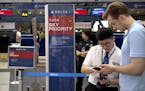 In this July 6, 2018 photo, a staff member assists a passenger near the check-in counters for Delta Air Lines at Beijing Capital International Airport