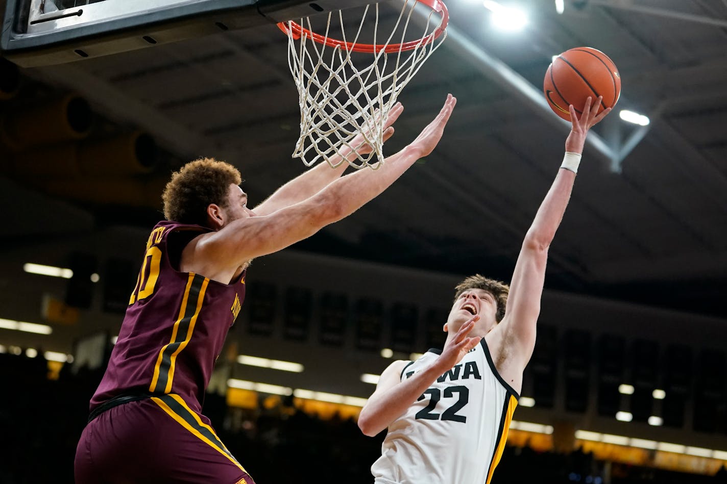 Iowa forward Patrick McCaffery (22) shoots over Minnesota forward Jamison Battle, left, during the second half of an NCAA college basketball game, Sunday, Feb. 6, 2022, in Iowa City, Iowa. (AP Photo/Charlie Neibergall)