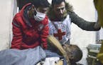 This Wednesday, Dec. 7, 2016 photo, released by the International Committee for the Red Cross, shows members of the Syrian Arab Red Crescent laying a 