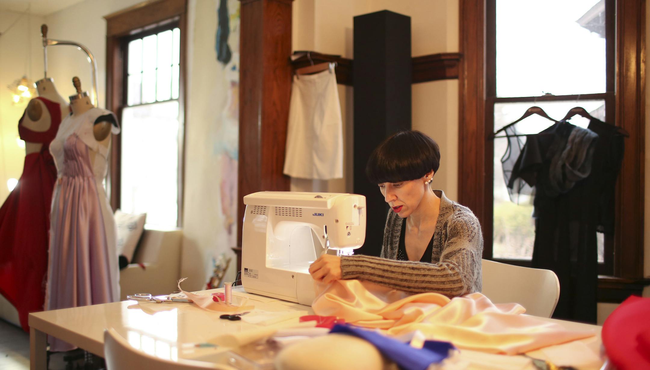 Emma Berg sewed one of the prom dresses in her Minneapolis workshop Wednesday evening. ] JEFF WHEELER ‚Ä¢ jeff.wheeler@startribune.com Emma Berg isn't the kind of fashion designer who plays it safe. Later this month, ten deserving high school teenagers will don prom dresses designed just for them at Berg's "I AM EVERYTHING" fashion show. Berg in her atelier and home in south Minneapolis Wednesday evening, April 2, 2014.