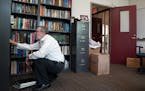 Outgoing president Eric Kaler organized his bookshelf as he unpacked boxes in his new office at Amundson Hall. ] ANTHONY SOUFFLE &#x2022; anthony.souf