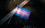 A Transgender Pride flag lays on the ground during a celebration of the Twin Cities Pride Festival.