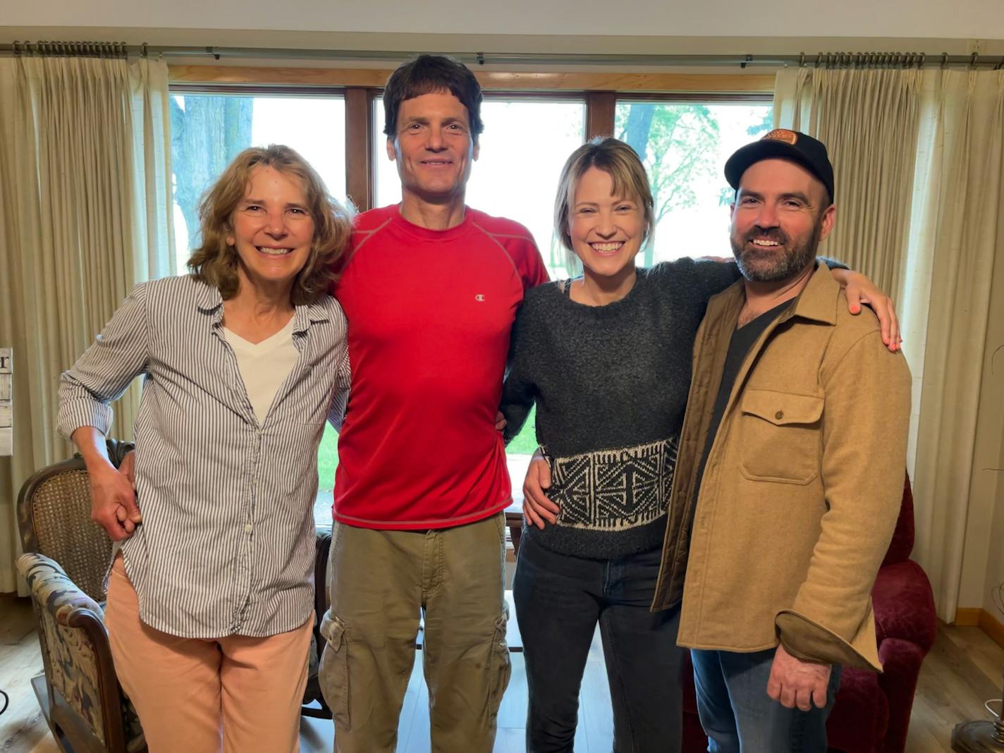 Four people with arms around one another smile for the camera.