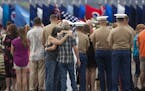 Unidentified family members embrace around a memorial for the 12 Marines who died when their helicopters crashed off the North Shore of Oahu, Hawaii, 