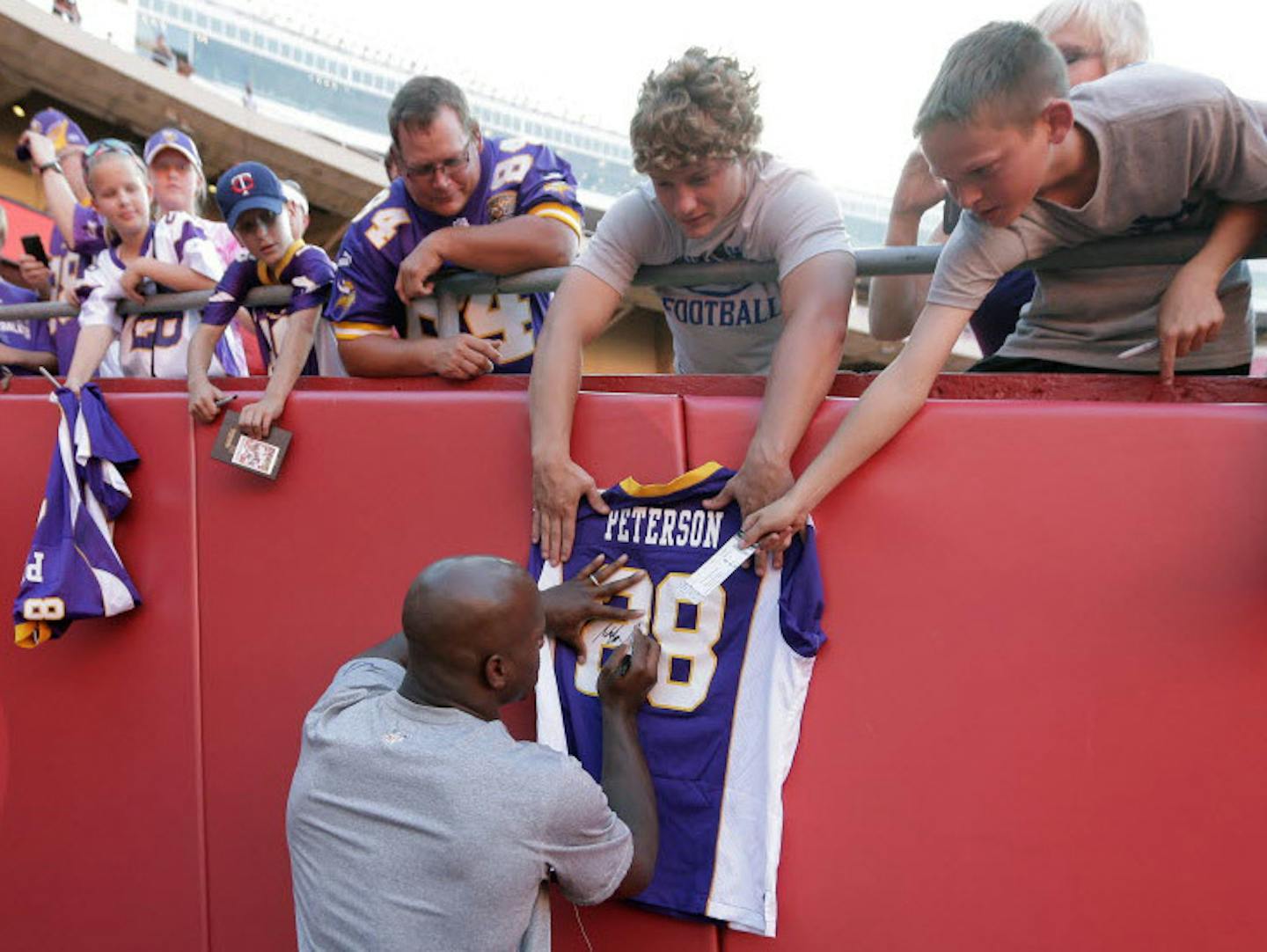 Minnesota Vikings running back Adrian Peterson signed autographs before an NFL preseason football game against the Kansas City Chiefs in Kansas City, Mo., Saturday, Aug. 23, 2014.