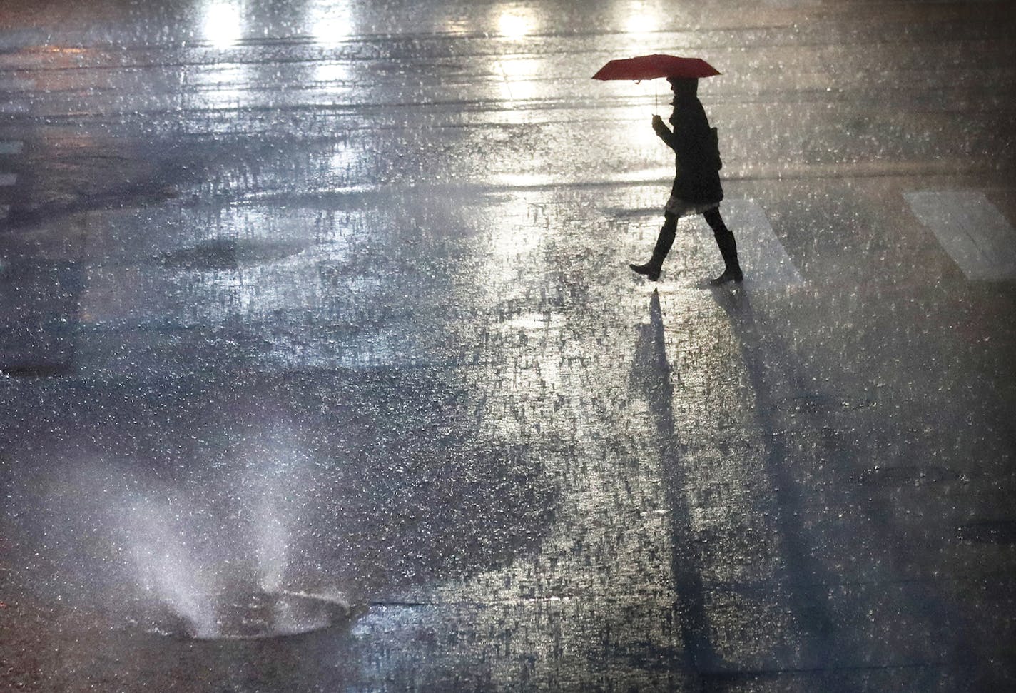 Rain water shoots out from a sewer cover along 2nd Ave. S, near S. 5th St. in downtown Minneapolis Thursday morning.