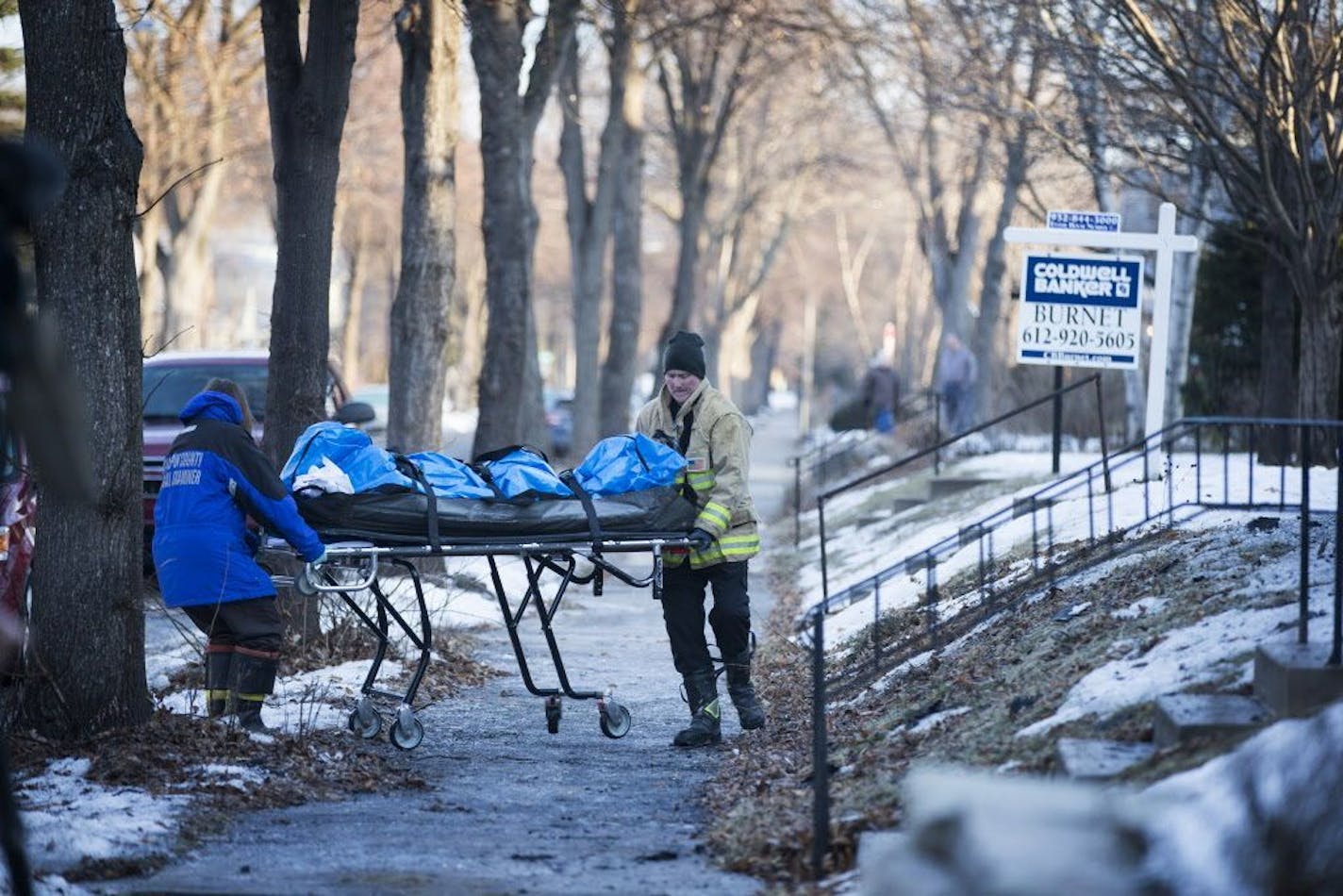 Authorities with the fire department and medical examiner's office bring a body bag out of a home where a fire killed one man in Minneapolis on Sunday, February 21, 2016.